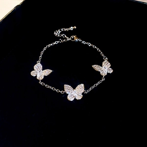 Detailed close-up of a silver butterfly bracelet with sparkling zircon stones on dark velvet