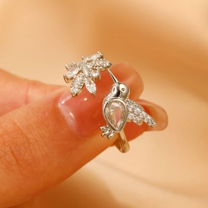 Macro detail of bird ring with hummingbird and flower design featuring sparkling crystals
