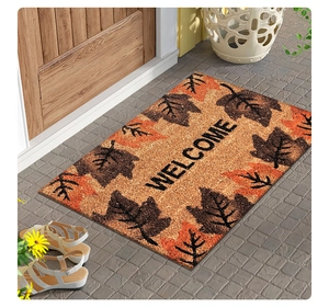 Gros plan d'un paillasson d'automne avec feuilles orange et inscription de bienvenue