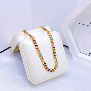 Chunky gold chain bracelet with colorful enamel links on a luxury white display box