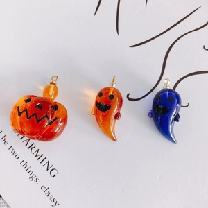 Macro shot of Halloween acrylic pumpkin and ghost charms with clear resin texture