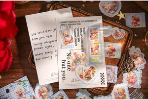 Retro teddy bear stickers and postcards arranged on a vintage tray for journaling