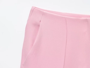 Dettaglio dei pantaloni svasati rosa con cuciture in vita e finiture delle tasche