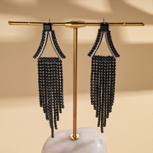 Gros plan de boucles d'oreilles à franges noires avec triangles géométriques et strass