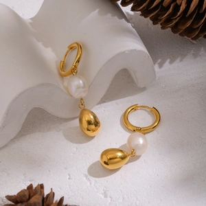 Baroque freshwater pearls and 18K gold plated drop earrings on white artistic pedestal