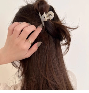 Elegant cream acetate hair claw clip for ponytail styling on minimalist model back view