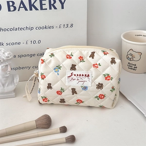 Gros plan de la trousse de maquillage matelassée avec motif ours et étiquette tissée