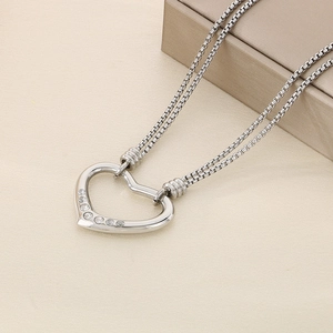 Detailed close-up of a silver heart pendant with sparkling crystals on a square link chain