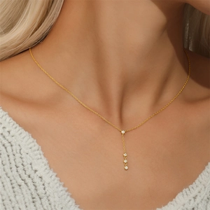 Detail of a gold S925 sterling silver Y-shaped necklace with four clear zircon stones