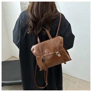 Zaino vintage marrone in ecopelle mostrato su una modella con cappotto nero invernale
