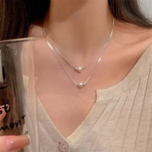 Dettaglio della collana a doppio strato in argento con perle naturali sulla modella