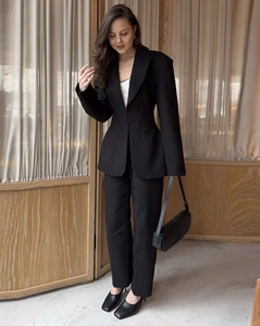 Detailed view of women's black slim fit business suit with tailored waist and elegant fabric