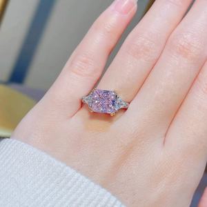 Pink radiant cut diamond ring in two-tone gold setting featuring triangle side stones