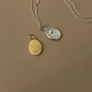 Close-up of S925 sterling silver tulip relief pendant and smooth gold finish pendant