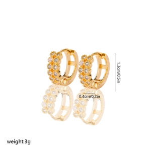 Detailed view of gold huggie earrings showing 1.3cm diameter and zircon inlay size