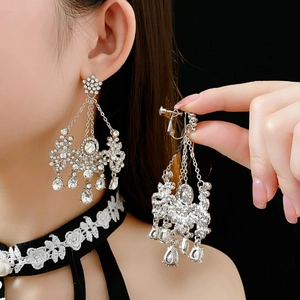 Detail of silver tassel chandelier earrings with sparkling rhinestones and ear clip mechanism