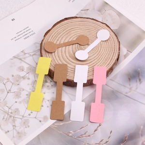 Variety of kraft paper jewelry price tags in dumbbell and rectangular shapes on wood