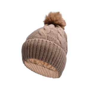 Detailed knit texture of khaki winter beanie with faux fur pompom and fleece lining