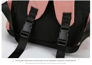Detail of adjustable shoulder strap buckles on a pink and black travel gym backpack