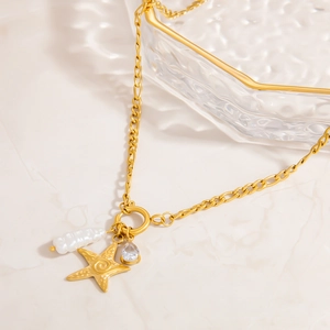 Detail of 18K gold necklace with starfish charm, baroque pearl, and blue zircon pendant