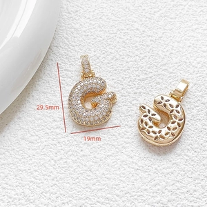 Macro detail of gold-plated letter G pendant with cubic zirconia and size dimensions