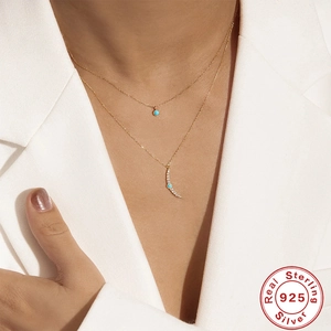 Double layered 925 sterling silver necklace featuring turquoise beads and a crescent moon pendant