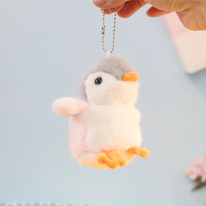Close-up of cute grey and pink plush penguin keychain with metal bead chain for backpacks