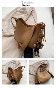 Detail of a brown hobo shoulder bag with a knit bunny charm and matte leather texture