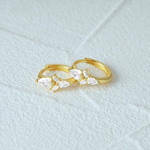 Detail view of gold S925 silver earrings with teardrop and rectangular cubic zirconia