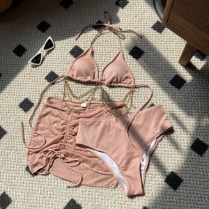 Pink sparkly 3-piece bikini set with gold chain detail and sheer wrap skirt