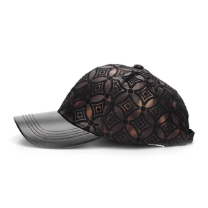 Détail de la broderie géométrique et de la visière en cuir noir sur la casquette
