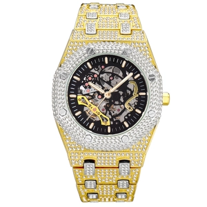 Macro detail of iced-out men's mechanical watch with skeleton dial and gold silver band
