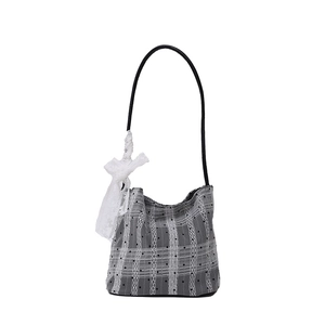 Gray plaid bucket bag with black polka dots and a white lace bow detail