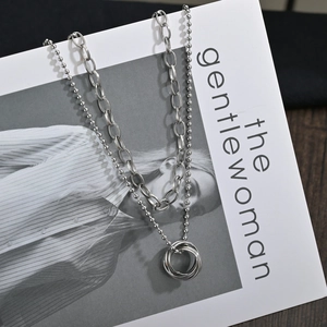 Modern double layer stainless steel necklace with multi-ring pendant on magazine