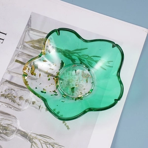 Macro shot of green flower petal resin dish with gold foil inlay for jewelry storage