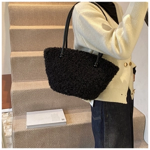 Détail de la texture en peau de mouton noire sur sac avec fines anses rondes