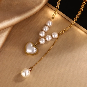 Elegant 18k gold plated stainless steel heart and pearl necklace on silk background