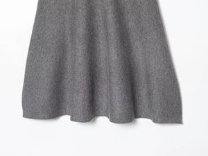 Detailed view of the gray knitted hemline showing high-quality fabric texture and drape