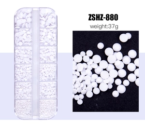 Macro shot of 12-grid organizer box filled with white resin nail art beads and pearls