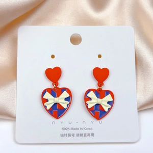 Detail of S925 silver needle heart earrings with blue plaid pattern and white bow