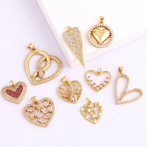 Macro shot of assorted 18K gold plated heart pendants with zirconia and pearl details
