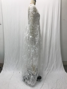Detail of white lace wedding dress featuring long sleeves and intricate floral embroidery