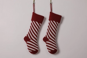 Detail of two knitted red and white striped Christmas stockings with hanging loops