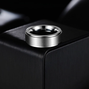 Brushed titanium steel minimalist ring for men with polished inner band on a black pedestal