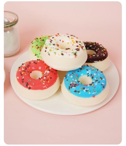Gros plan de cinq beignets en PU colorés avec pépites sur une assiette en céramique