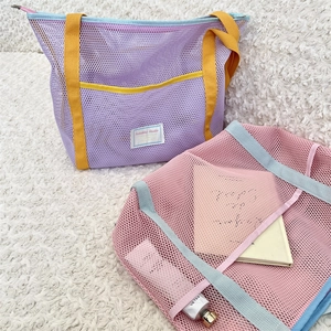 Close-up of mesh beach tote bag with Sorakha Studio label and yellow handle details