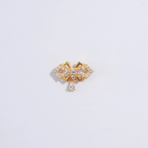 Macro shot of gold bow pendant with white zircon pavé and teardrop crystal drop