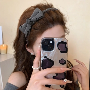 Grey knitted headband with black polka dot bow design for a stylish voluminous hair look