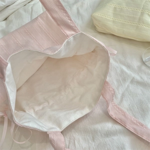 Vista dettagliata della borsa tote in tela rosa con fodera bianca e bordo in pizzo