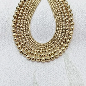 Detailed macro view of layered 18K gold stainless steel bead necklace with mirror finish
